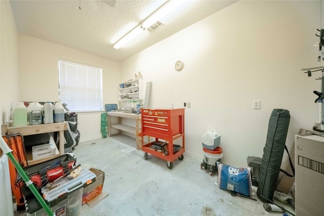 misc room featuring a textured ceiling and concrete flooring