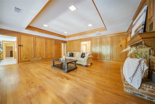 living room featuring light hardwood / wood-style floors and a raised ceiling