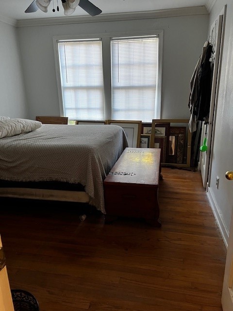 bedroom with ornamental molding, ceiling fan, and dark hardwood / wood-style flooring