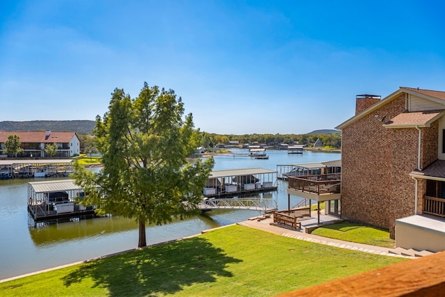 dock area featuring a water view and a lawn