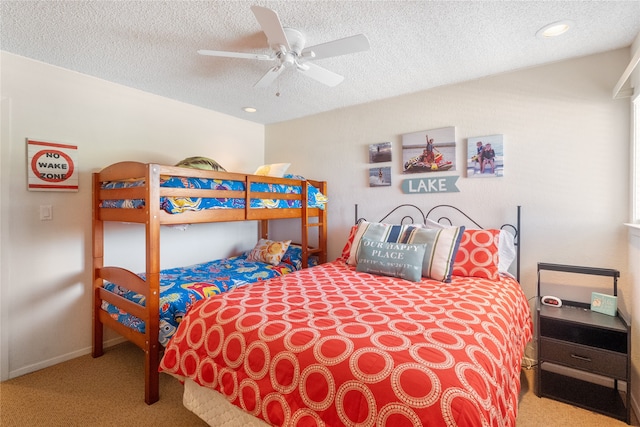 bedroom featuring light carpet, a textured ceiling, and ceiling fan