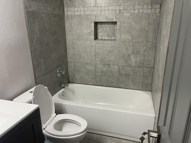 full bathroom featuring vanity, tiled shower / bath combo, and toilet