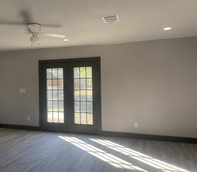 unfurnished room with hardwood / wood-style floors, ceiling fan, a wealth of natural light, and french doors