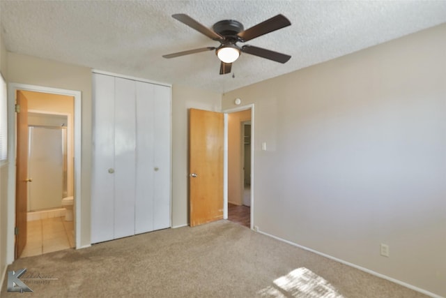 unfurnished bedroom featuring ceiling fan, light colored carpet, a textured ceiling, and a closet