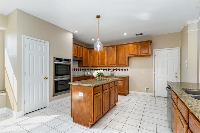 kitchen with light stone countertops, stainless steel appliances, light tile patterned floors, tasteful backsplash, and a kitchen island