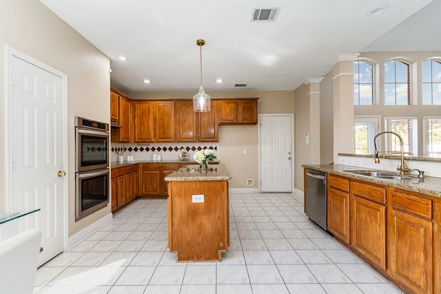 kitchen featuring light stone countertops, sink, stainless steel appliances, light tile patterned floors, and a kitchen island