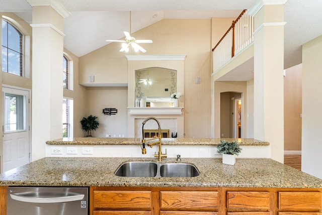 kitchen featuring light stone countertops, ceiling fan, dishwasher, and sink