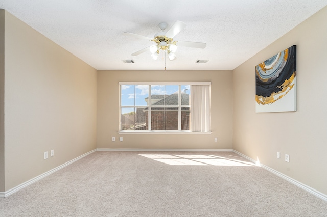 carpeted empty room featuring ceiling fan and a textured ceiling