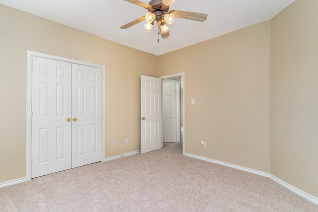 unfurnished bedroom with ceiling fan, a closet, and light carpet