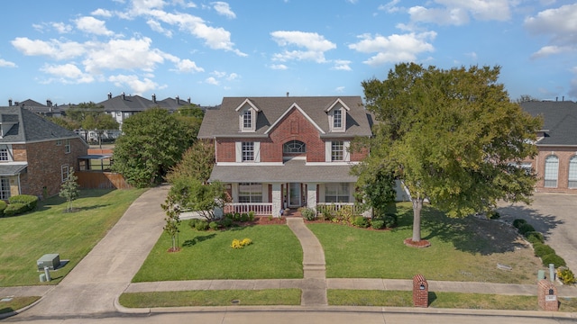 view of front of home featuring covered porch and a front lawn