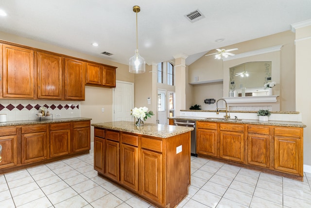 kitchen with light stone countertops, stainless steel dishwasher, sink, light tile patterned floors, and hanging light fixtures