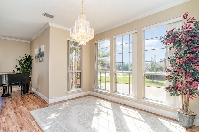 dining area featuring a notable chandelier, crown molding, and light hardwood / wood-style flooring