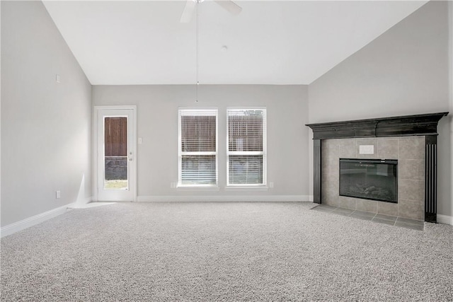 unfurnished living room featuring a healthy amount of sunlight, lofted ceiling, and light colored carpet