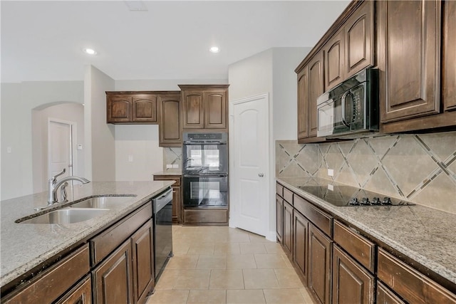 kitchen featuring tasteful backsplash, black appliances, sink, and light stone counters