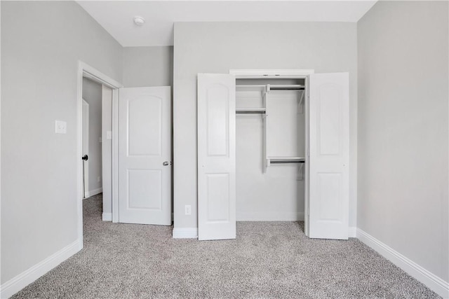 unfurnished bedroom featuring a closet and light colored carpet