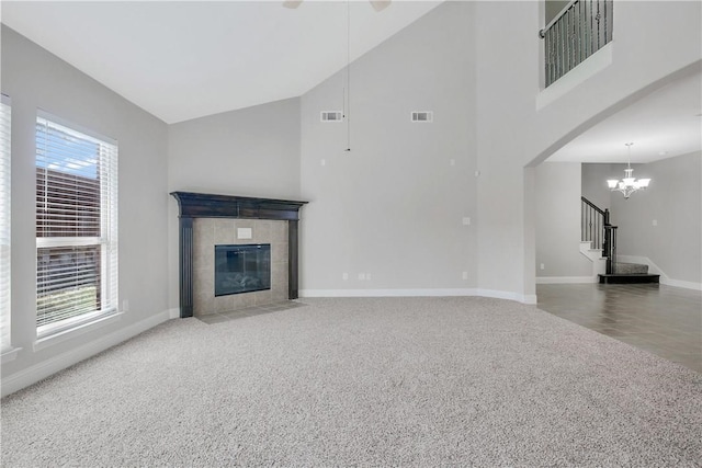 unfurnished living room with high vaulted ceiling, carpet flooring, and a wealth of natural light