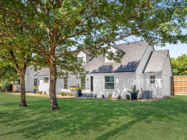 back of property featuring central AC and a lawn