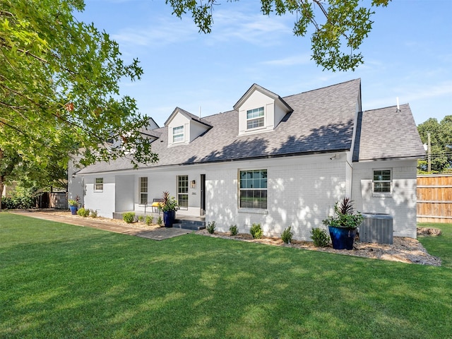 view of front of home with cooling unit and a front lawn