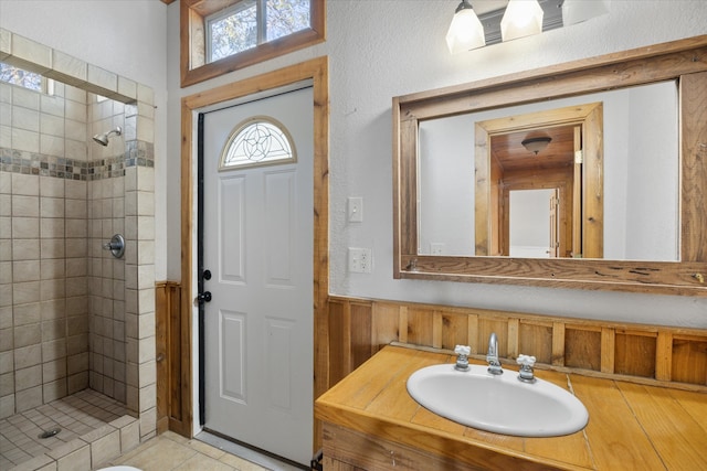 bathroom featuring vanity, wooden walls, and a tile shower