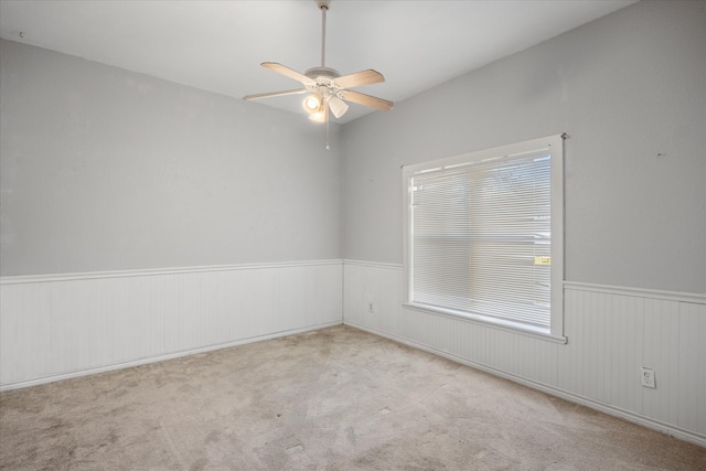 spare room featuring ceiling fan, light carpet, and plenty of natural light