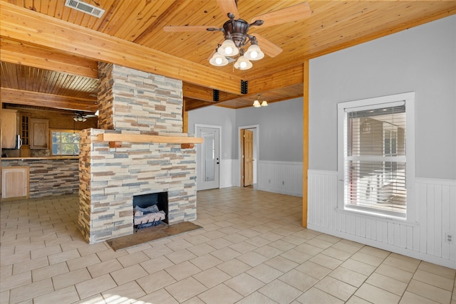 unfurnished living room with wood ceiling, beam ceiling, ceiling fan, light tile patterned flooring, and a stone fireplace