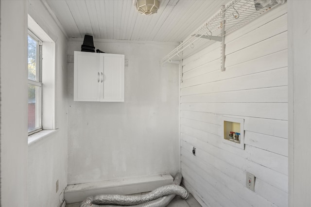 washroom with hookup for a washing machine, wood ceiling, cabinets, and wooden walls