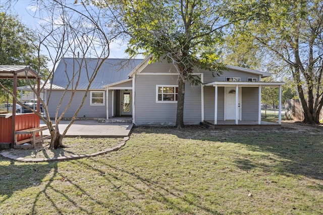 back of house with a yard and a patio