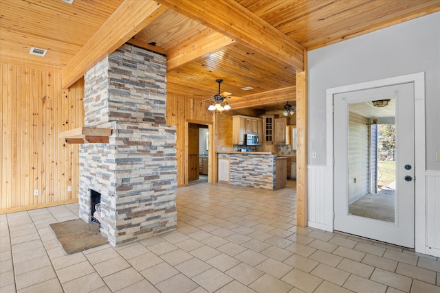 kitchen featuring wood ceiling, wood walls, beamed ceiling, and light tile patterned floors