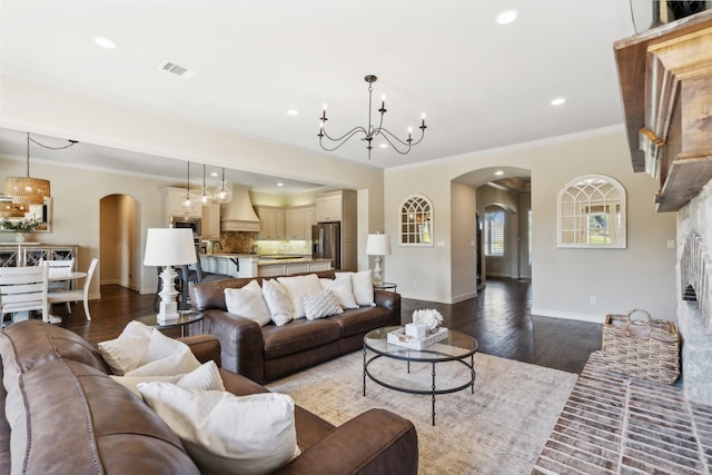 living room with dark hardwood / wood-style floors, ornamental molding, and a chandelier