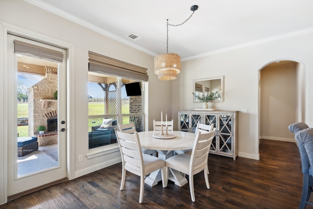 dining space with crown molding and dark wood-type flooring