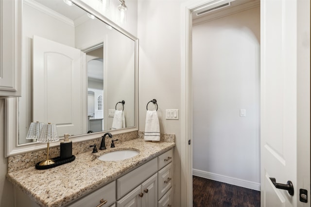 bathroom featuring hardwood / wood-style floors, vanity, and crown molding