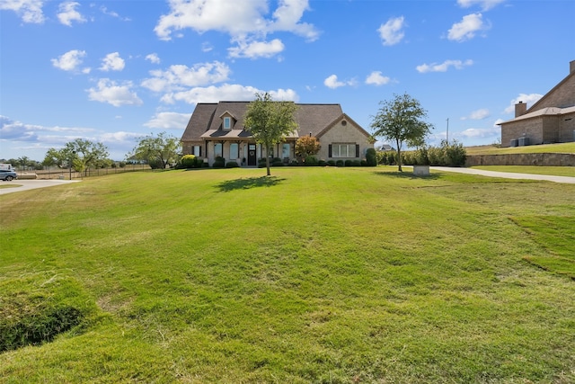 cape cod house featuring a front yard