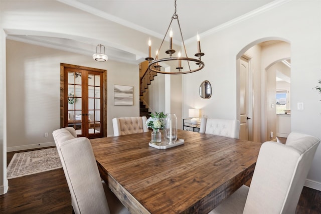 dining space featuring a chandelier, french doors, ornamental molding, and dark wood-type flooring