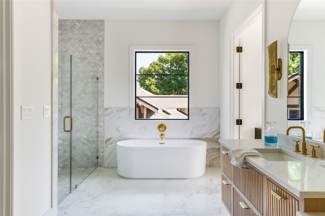 bathroom featuring shower with separate bathtub, vanity, a wealth of natural light, and tile walls