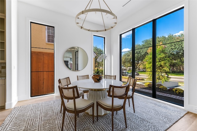 dining room featuring light wood-style flooring and a notable chandelier