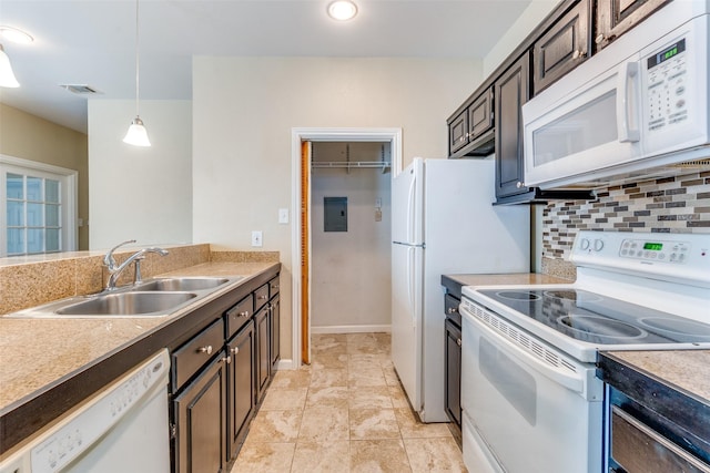 kitchen featuring dark brown cabinetry, sink, hanging light fixtures, and white appliances