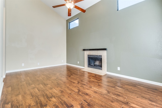 unfurnished living room with hardwood / wood-style flooring, ceiling fan, and high vaulted ceiling