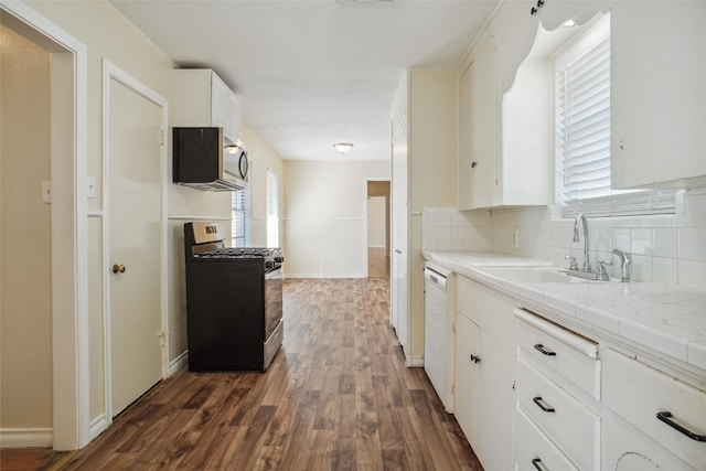 kitchen featuring sink, backsplash, dark hardwood / wood-style flooring, stainless steel appliances, and white cabinets