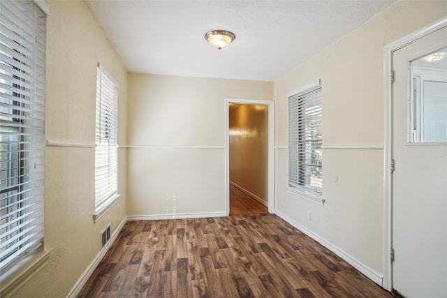 unfurnished room with dark wood-type flooring