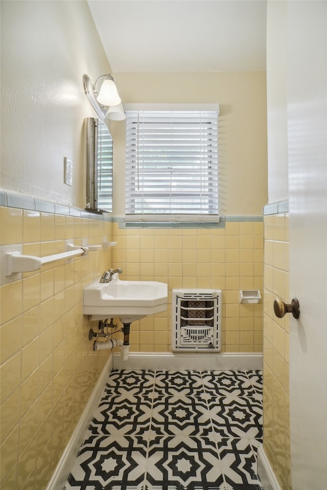 bathroom featuring tile walls, sink, heating unit, and tile patterned flooring