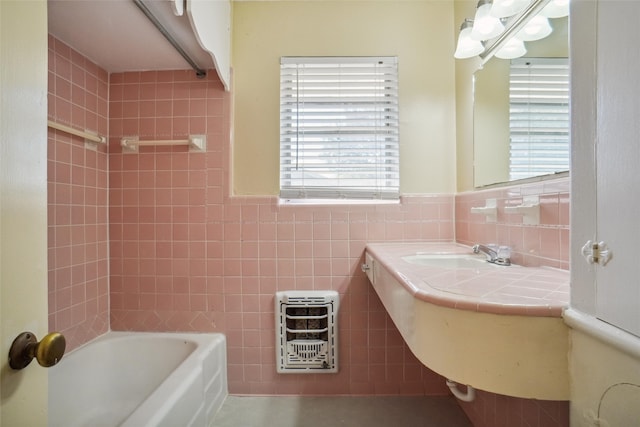 bathroom with tile walls, sink, heating unit, and plenty of natural light