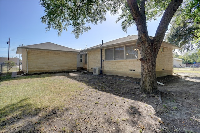 rear view of property featuring a yard and ac unit