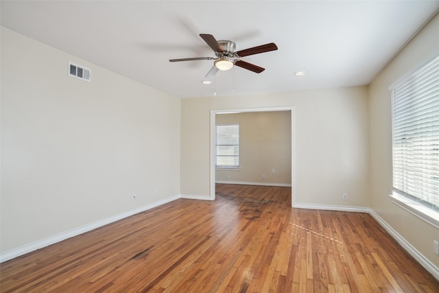 empty room featuring light hardwood / wood-style flooring, a healthy amount of sunlight, and ceiling fan