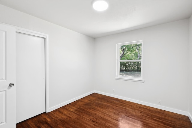 unfurnished bedroom with a closet and dark wood-type flooring