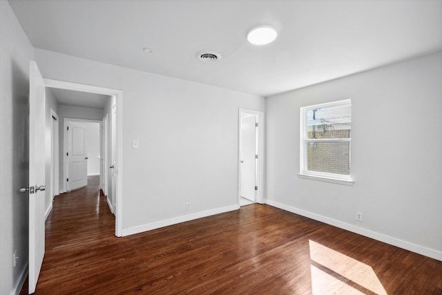 spare room featuring dark wood-type flooring