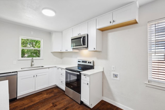 kitchen featuring dark hardwood / wood-style flooring, white cabinetry, sink, and appliances with stainless steel finishes