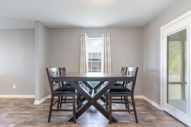 dining area with baseboards and wood finished floors