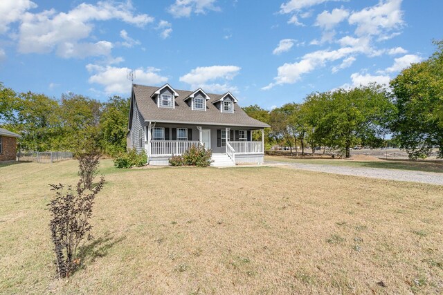 cape cod house featuring a porch and a front lawn