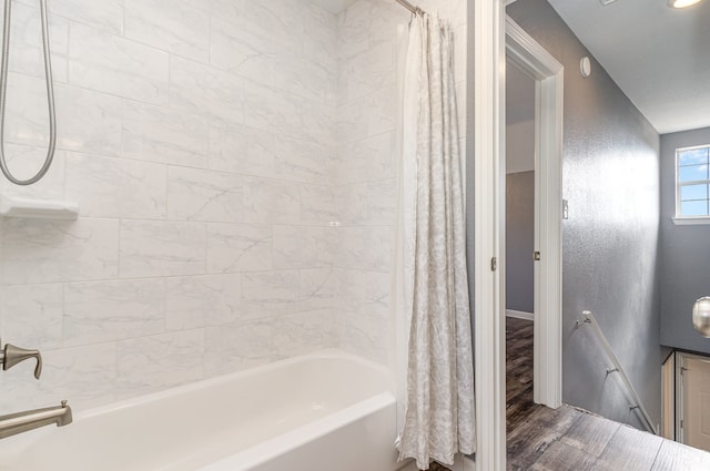 full bathroom featuring shower / tub combo, baseboards, and wood finished floors