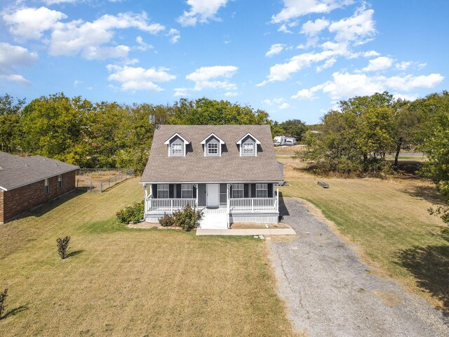 cape cod home featuring covered porch and a front lawn